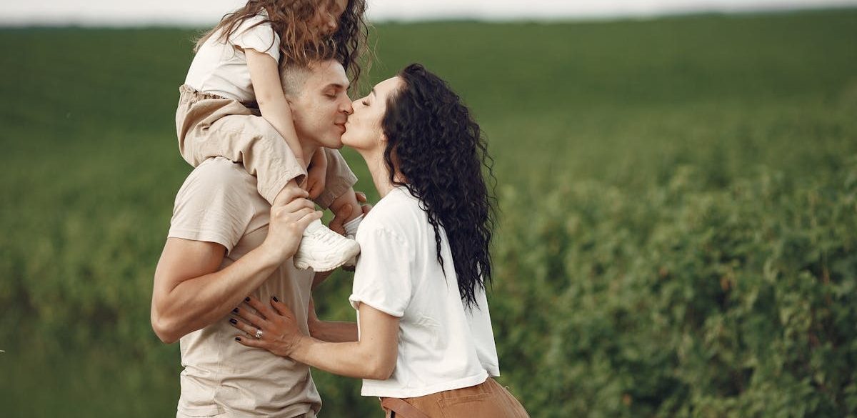 A heartwarming family moment captured in a field, highlighting love and togetherness.
